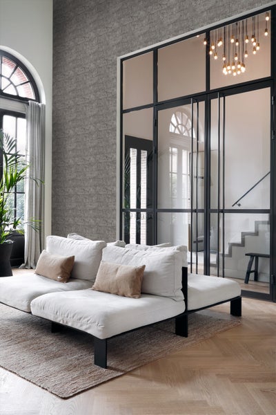 Wohnzimmer mit Sofa, Kissen, Teppich, Tapete und Raumteiler