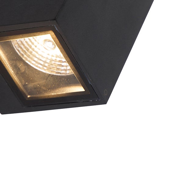 Nahaufnahme einer schwarzen quadratischen LED-Außenwandleuchte mit warmweißem Licht.