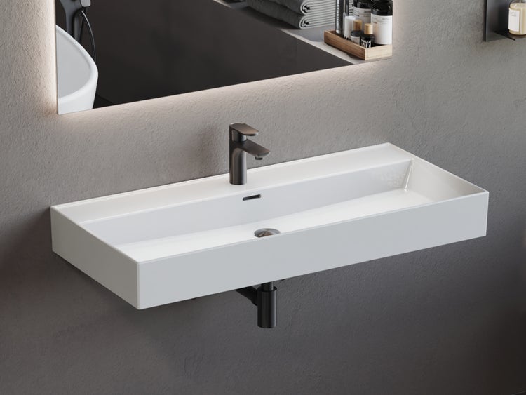 Modernes, rechteckiges Wand-Waschbecken in Weiß mit schwarzer Armatur und schwarzem Siphon in einem Badezimmer.