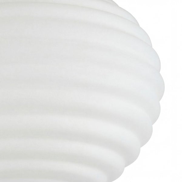 Detailaufnahme eines weißen Lampenschirms mit gerippter und gewellter Oberfläche.