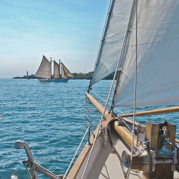 Segelboot auf dem Meer mit Blick auf einen Leuchtturm
