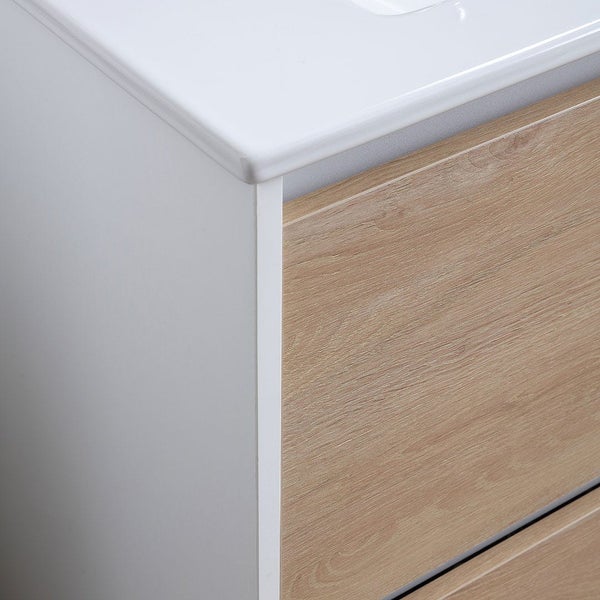 Nahaufnahme eines Badezimmer-Unterschranks mit weißem Korpus, Front in Eichenholzoptik und weißem Waschtisch.