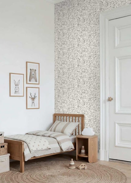 Helles Kinderzimmer mit Holzbett, gemusterter Tapete, Tierbildern an der Wand und einem runden Juteteppich.
