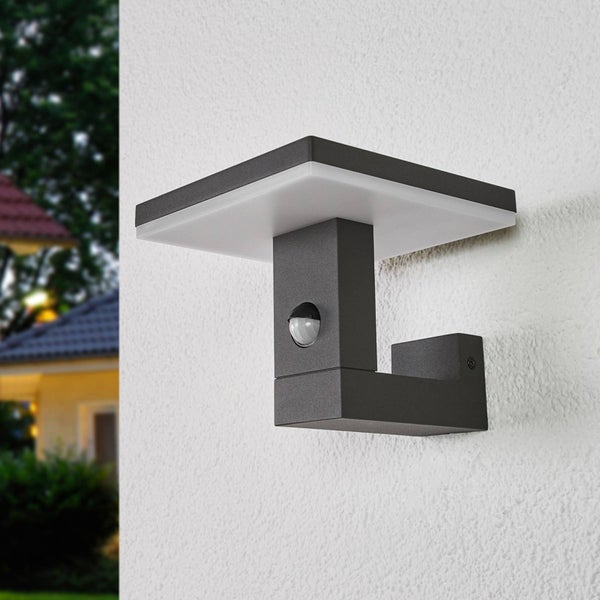 Moderne LED-Außenwandleuchte in Anthrazit mit Bewegungsmelder, montiert an einer hellen Hauswand.