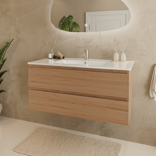 Modernes Badezimmer mit wandhängendem Waschtischunterschrank in Holzoptik, zwei Schubladen, weißem Waschtisch, verchromter Armatur und Spiegel.