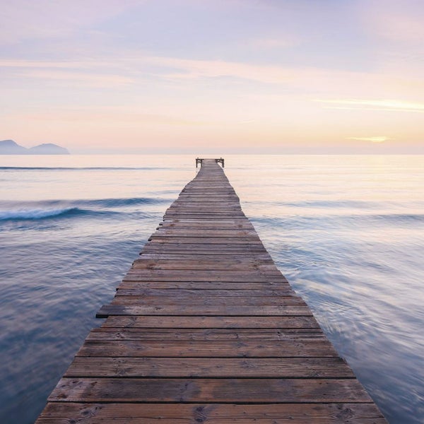 Ein Holzsteg erstreckt sich ins Meer.