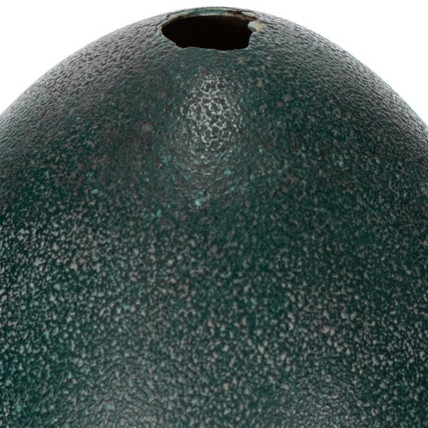 Detailaufnahme der strukturierten Oberfläche eines runden Gartenobjekts mit einer Öffnung oben.