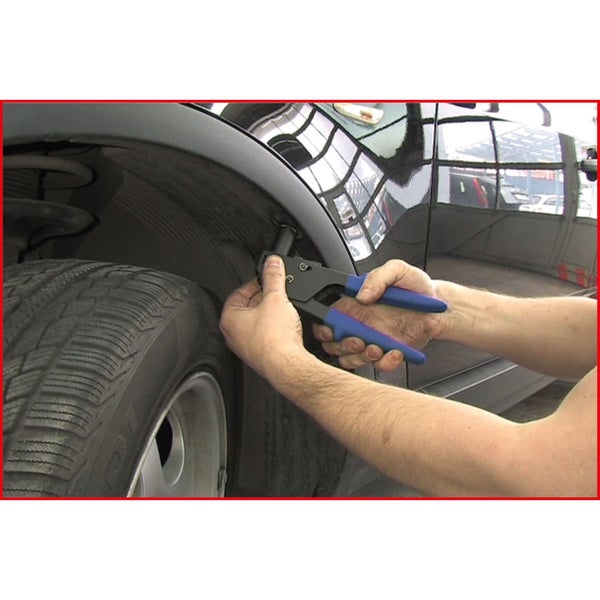 Eine Person verwendet eine Nietzange an einem Fahrzeug.