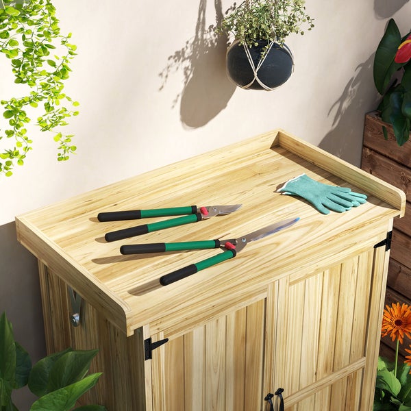 Gartenschrank aus Holz mit Gartenschere und Gartenhandschuhen auf der Oberseite