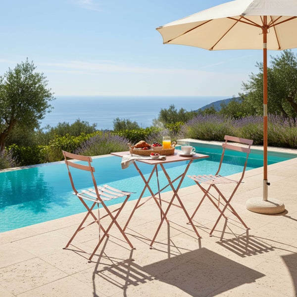 Bistro-Set bestehend aus einem quadratischen Klapptisch und zwei Klappstühlen aus Metall auf einer Steinterrasse am Pool mit Meerblick.