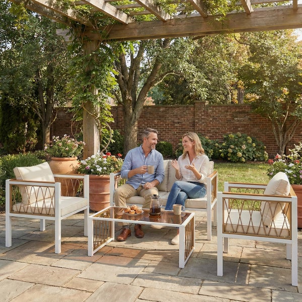 Modernes Garten-Lounge-Set aus weißem Metall mit Seilgeflecht und Holzdetails auf einer sonnigen Terrasse inmitten eines blühenden Gartens.