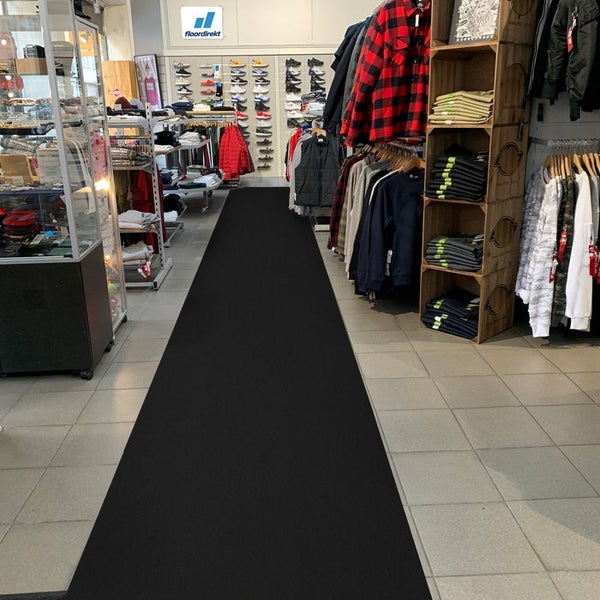 Schwarzer Läufer in einem Bekleidungsgeschäft auf Fliesenboden