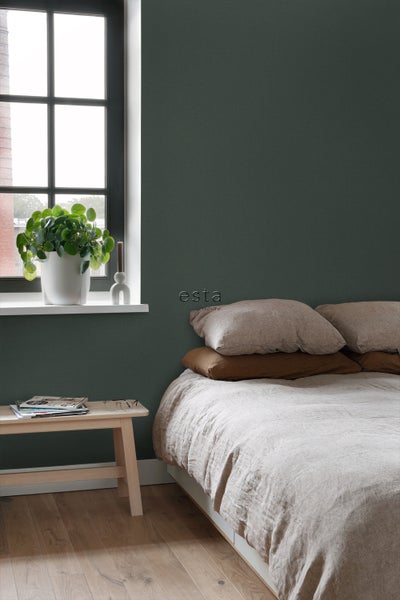 Schlafzimmer mit Bett und grüner Tapete