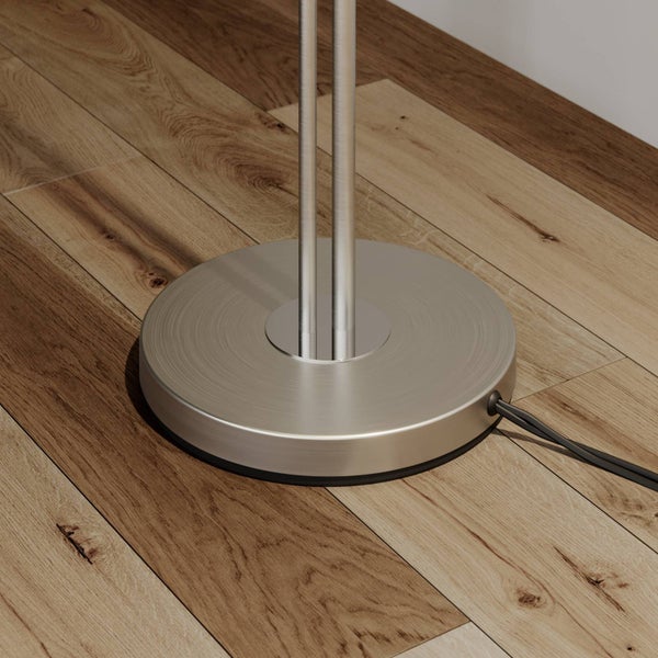 Detailaufnahme des Fußes einer Stehlampe aus Metall auf einem Holzboden