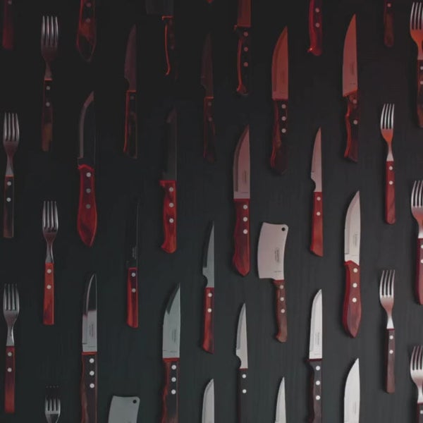 Muster aus Messern und Gabeln auf dunklem Untergrund.