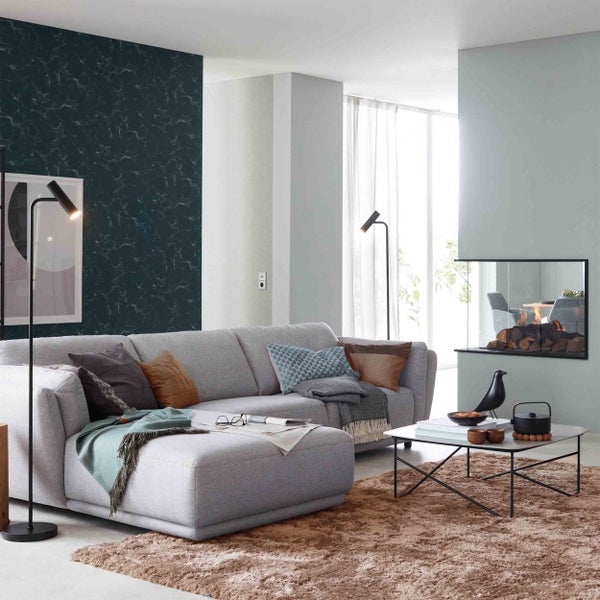 Helles Wohnzimmer mit grauem Ecksofa, Akzentwand in Marmoroptik, modernem Kamin und Hochflor-Teppich. Geräumige und organisierte Einrichtung.