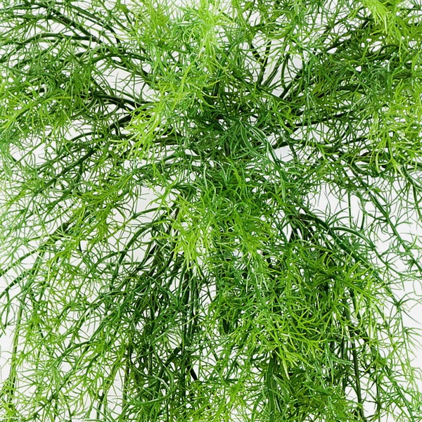 Künstliche Pflanze im braunen Terrakottatopf mit grünen Blättern.