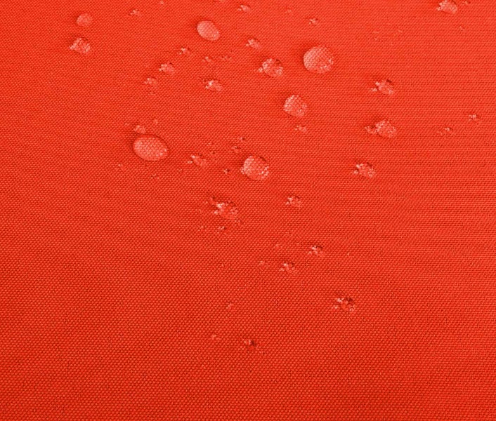 Nahaufnahme von Wassertropfen auf einem wasserabweisenden Stoffgewebe.