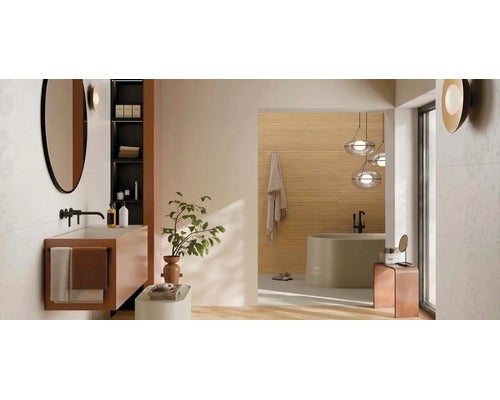Modernes, helles Badezimmer mit Waschtischunterschrank, Rundspiegel, ovaler Badewanne und großen Fliesen in minimalistischem Design.