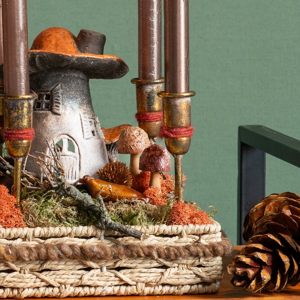 Dekorative Pilzhaus-Kerzenhalter-Szene in einem Korb