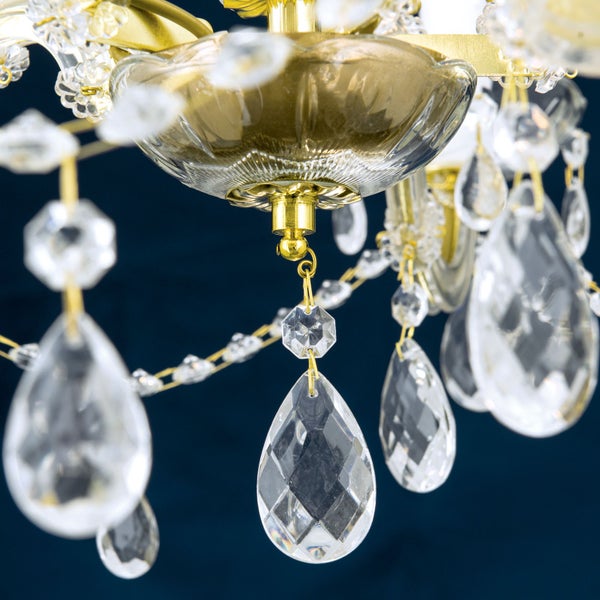 Detailaufnahme eines Kronleuchters mit facettierten Kristallbehängen und Metallgestell.