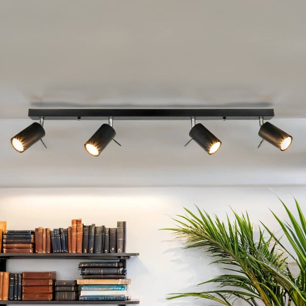 Deckenleuchte mit vier Strahlern und Büchern im Hintergrund