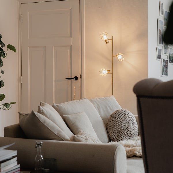 Wohnzimmer mit Sofa und Stehlampe mit drei Leuchten