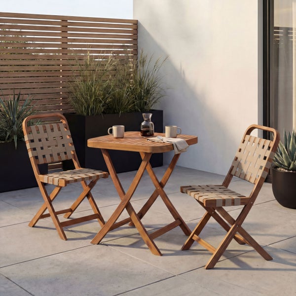 Modernes Gartenmöbel-Set aus Holz mit Klapptisch und zwei Stühlen mit Geflecht auf einer Steinterrasse mit Holz-Sichtschutz.