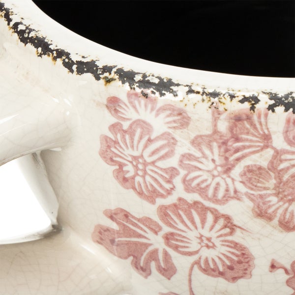 Nahaufnahme eines Keramiktopfes mit rosa Blumenmuster, Krakelee-Glasur und antik wirkendem Rand.