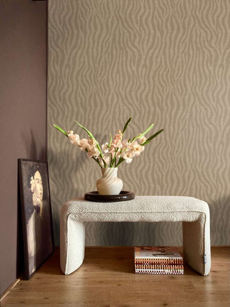 Wohnzimmer mit Vliestapete mit geschwungenem Streifenmuster, einer Sitzbank aus Boucle-Stoff, einer Vase mit Gladiolen und einem gerahmten Bild.