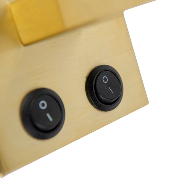 Detailansicht eines goldenen Lampensockels mit zwei schwarzen Schaltern