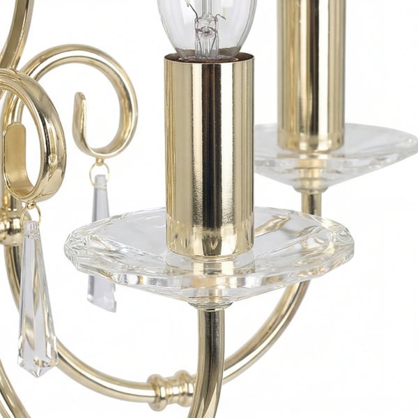 Detail einer goldenen Leuchte mit Lampenfassung und Kristallanhängern