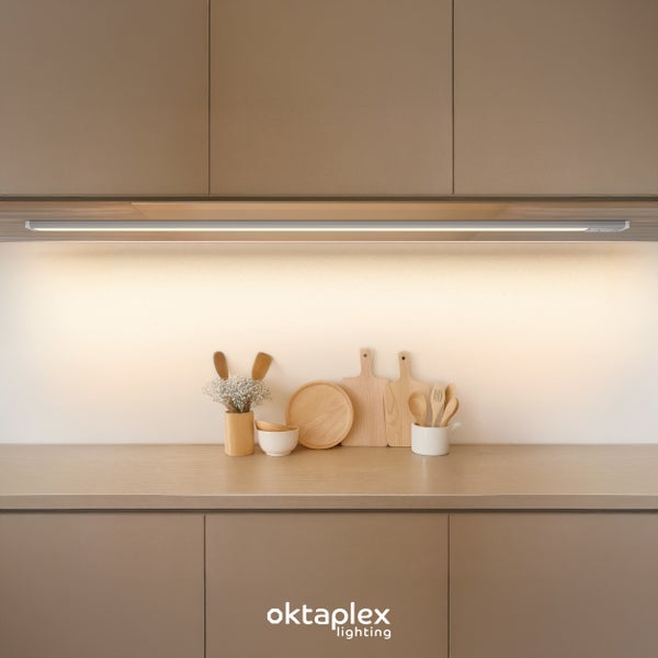 Oktaplex Lighting LED Unterbauleuchte unter modernen Küchenschränken mit warmer Beleuchtung auf der Arbeitsplatte und Küchenutensilien