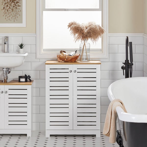 Badezimmer mit Waschbecken, Badewanne und Badmöbeln mit Lamellentüren