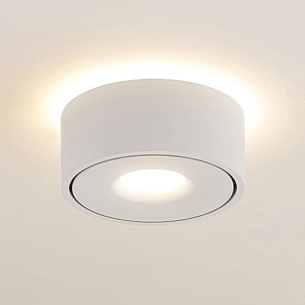 Runde weiße Deckenaufbauleuchte mit direktem Lichtaustritt nach unten und indirektem Lichtschein an der Decke.