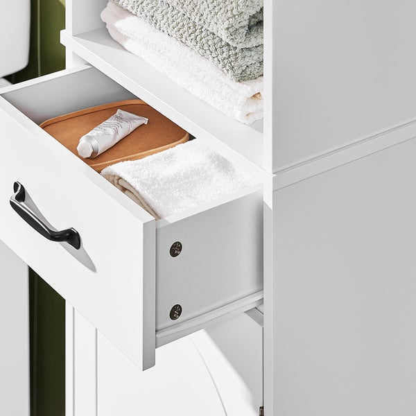 Detailaufnahme eines weißen Badezimmerschranks mit offener Schublade, in der Handtücher und eine Tube liegen.