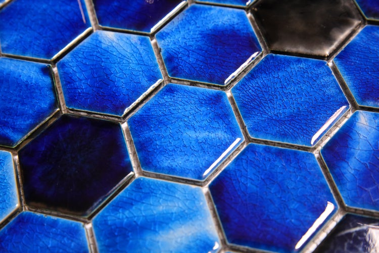Nahaufnahme von blauen Sechseckfliesen mit Craquelé-Effekt