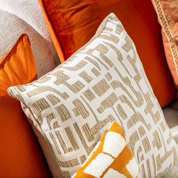 Nahaufnahme eines Sofas mit Kissen und einer Decke mit Fransen