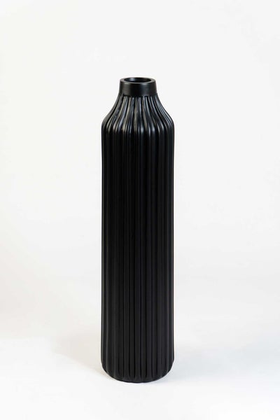 Schwarze, hohe, zylindrische Vase mit vertikaler Rillenstruktur.