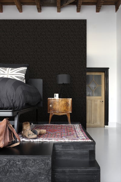 Schlafzimmer mit Bett, Nachttisch, Teppich und gemusterter Tapete