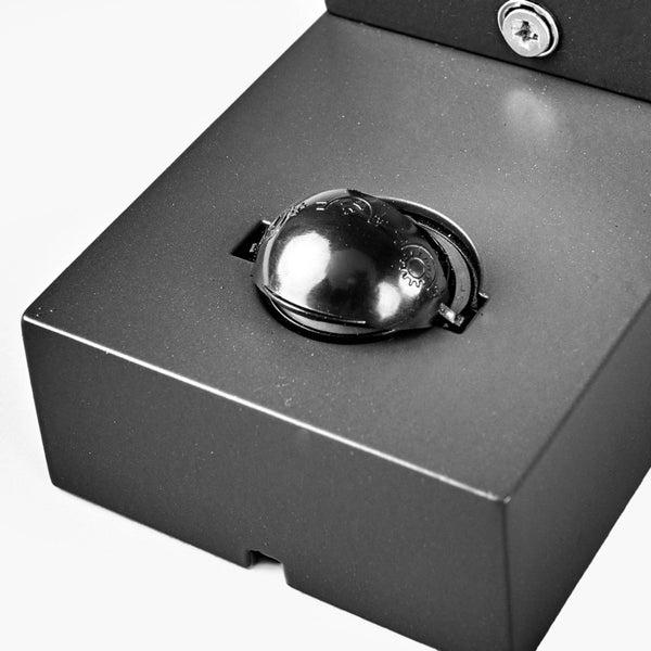 Nahaufnahme eines Bewegungssensors mit Einstellung für die Lichtempfindlichkeit auf einem schwarzen Gehäuse.