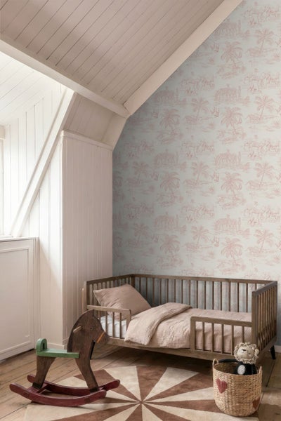 Kinderzimmer mit Safari-Tapete, Holzbett, Schaukelpferd und rundem Teppich unter einer Dachschräge.