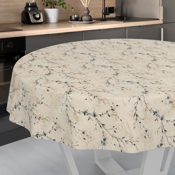 Runde Tischdecke mit filigranem Muster aus Zweigen und Blüten auf einem Tisch in einer modern eingerichteten, hellen Küche.