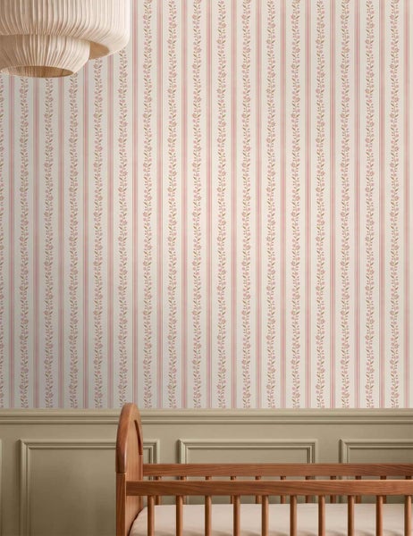 Klassische Vliestapete mit vertikalem Streifenmuster und Blumenranken im hellen Kinderzimmer über Wandtäfelung und Kinderbett aus Holz.