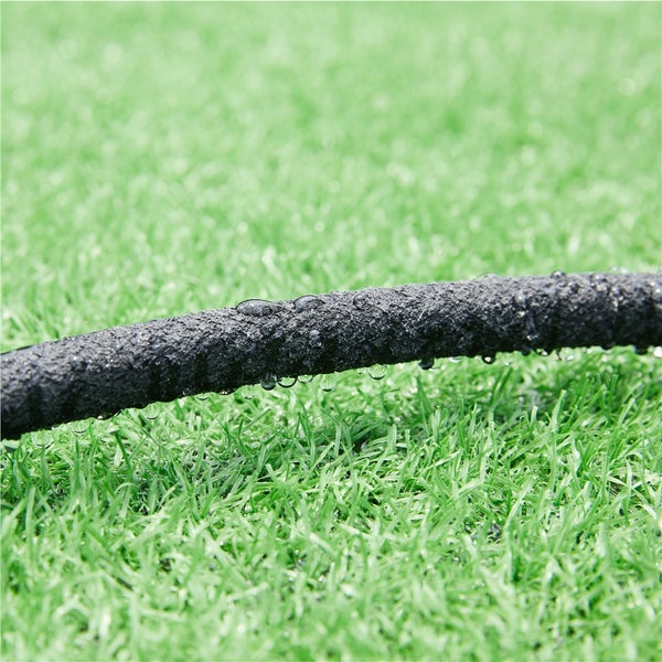 Bewässerungsschlauch auf Rasen mit Wassertropfen