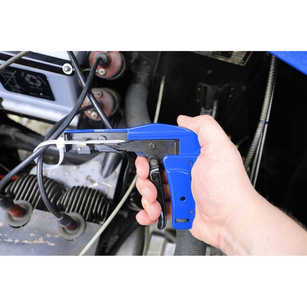 Hand, die eine Kabelbinderpistole an einem Motor verwendet