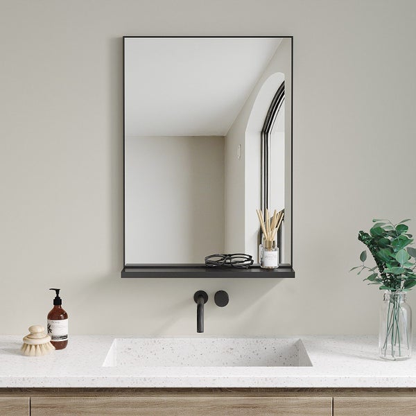 Wandspiegel mit integrierter Ablage über einem Waschbecken mit Unterputzarmatur und Steinwaschtischplatte in einem modernen Badezimmer.