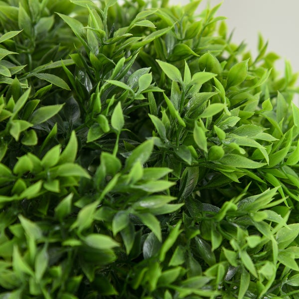 Nahaufnahme von grünen Blättern einer künstlichen Buchsbaumkugel.