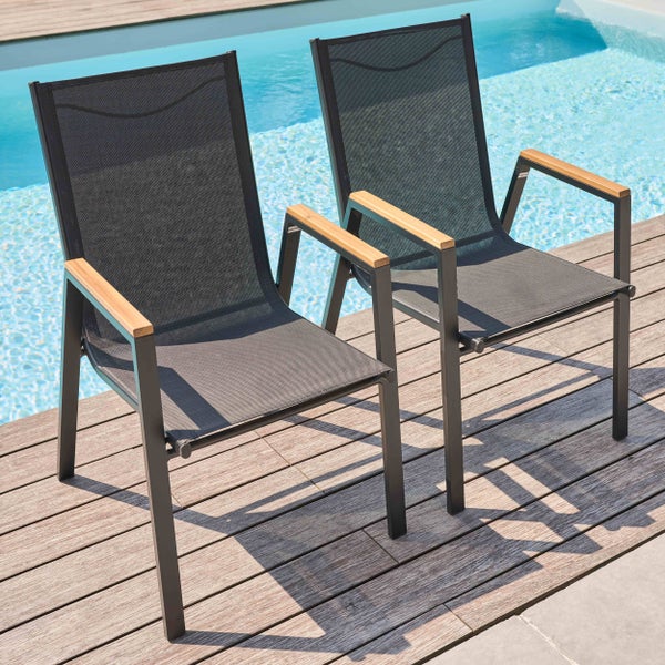 Zwei moderne Gartenstühle mit schwarzem Netzgewebe, Metallgestell und Holzarmlehnen auf einer Holzterrasse am Pool.