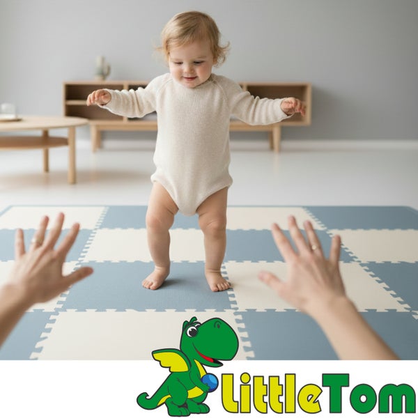 Ein Kleinkind steht auf einer blau-weiß gemusterten Puzzlematte aus Schaumstoff in einem hellen Wohnzimmer. LittleTom Logo.